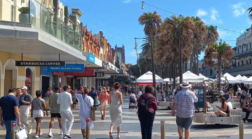 The Corso, Manly, today — a pedestrian-only strip full of people, markets and palm trees